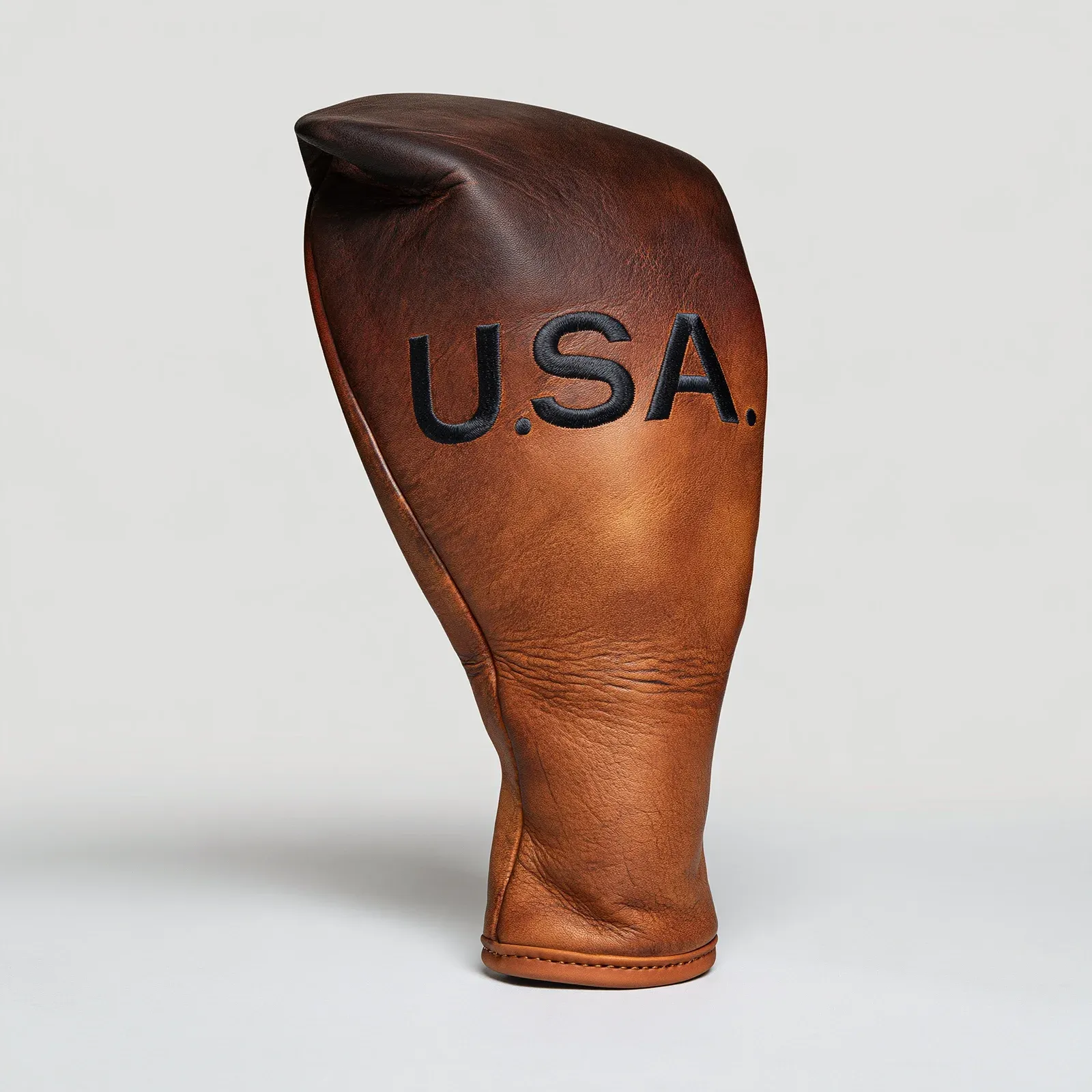 A leather golf driver head cover rendered in a neutral studio, two-tone leather with stitching.